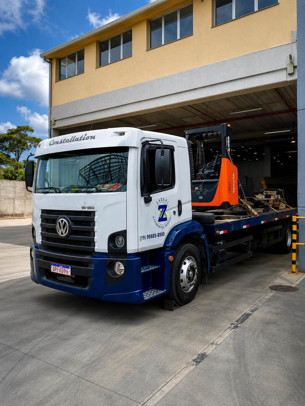 Caminhão Zazeri carregando empilhadeira em galpão